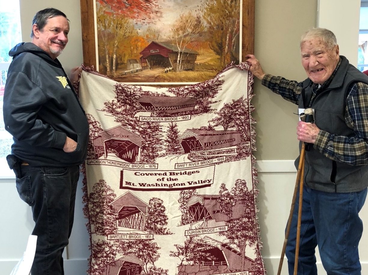 Man holding up antique quilt